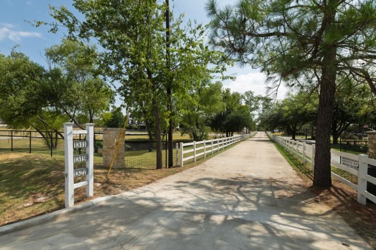 Long entry drive with white fencing at 1311 Mount Gilead Rd, Keller TX