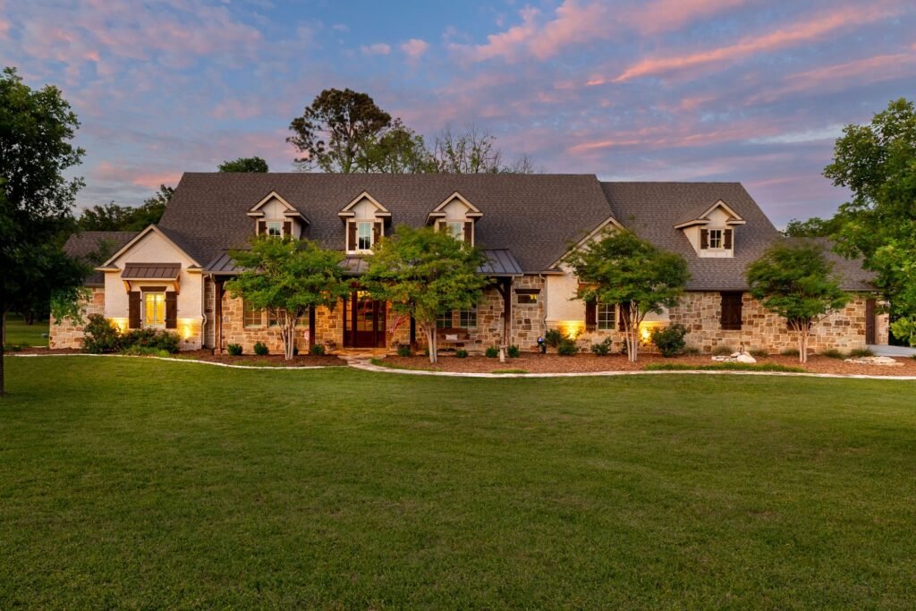 Front of 1331 Bancroft Road in Keller, TX at twilight, a stone and siding custom farmhouse on 4.6 acres