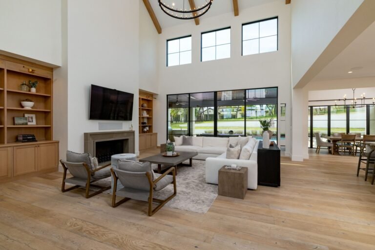 Two-story family room with fireplace, built-in shelving, and wall of windows at 1412 Chelsea Rae Lane, Keller TX