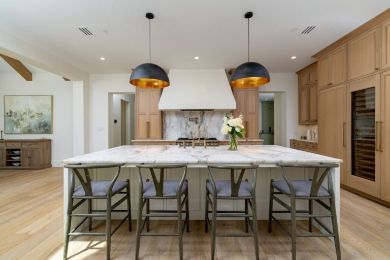 Chef's kitchen with marble island, gold pendant lights, and white oak cabinetry at 1412 Chelsea Rae Lane, Keller TX