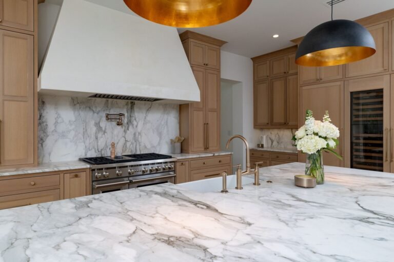 Kitchen range wall with marble backsplash, plaster hood, and wine refrigerator at 1412 Chelsea Rae Lane, Keller TX