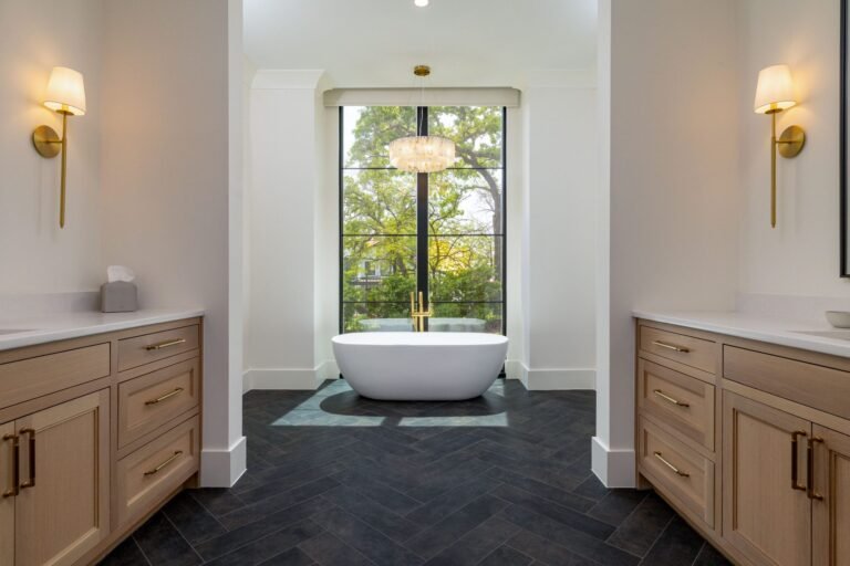 Primary bath with freestanding tub, double vanities, and herringbone tile at 1412 Chelsea Rae Lane, Keller TX